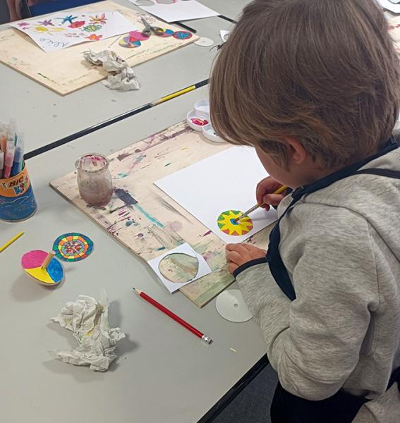 un enfant est en train de peindre le cadran d'une toupie