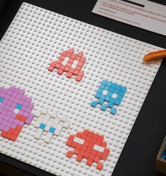 illustration de petits personnages en pixel art assemblés sur une planche lego