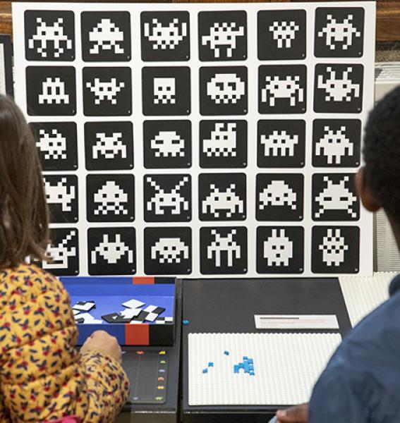 deux enfants vus de dos regardant des exemples de Space Invaders