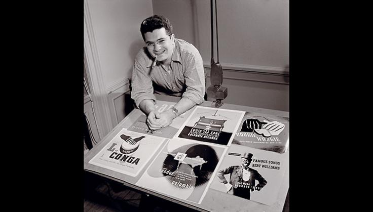 Alex Steinweiss devant certaines des pochettes qu'il a créés, 1947, Photoo William P. Gottlieb, CC2