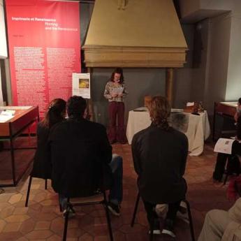 Une comédienne déclame un texte dans les salles d'exposition du musée