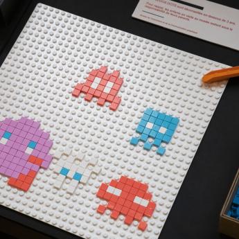 illustration de petits personnages en pixel art assemblés sur une planche lego